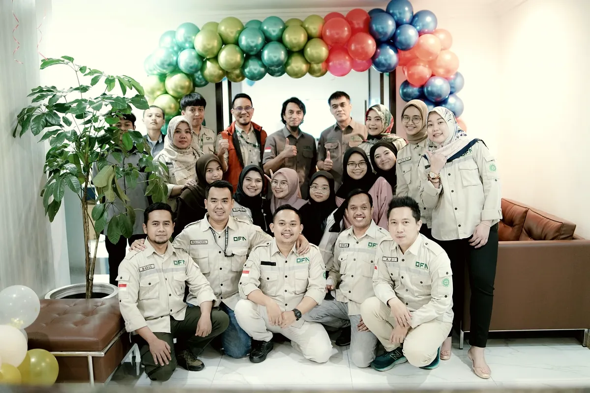 OFN staff in company uniform gathered for a group photograph at a company anniversary.