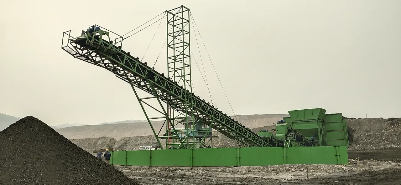 OFN crushing plant, its green steel conveyor rising from the crusher house above a coal stockpile.