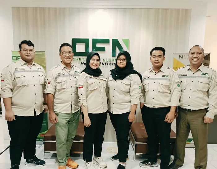 Six OFN staff in company uniform standing in front of an OFN backdrop at a site office.